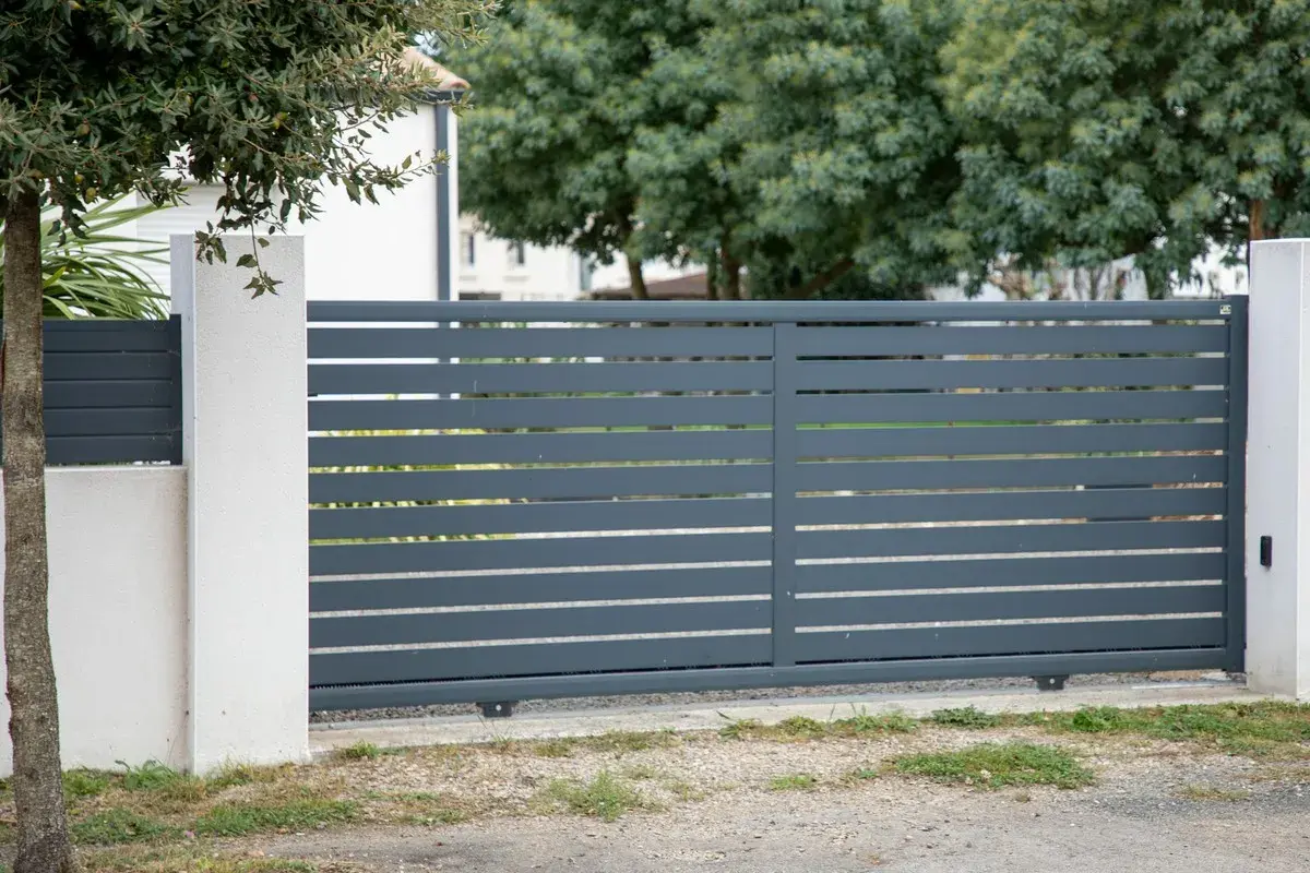 Grafitowa brama przesuwna w ogrodzeniu